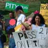 photo of small group of protesters; signs read 